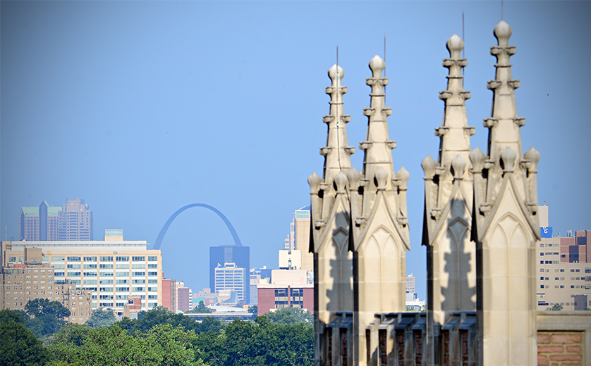 A photo of downtown St. Louis from a rooftop perspective, with the Arch in the distance.